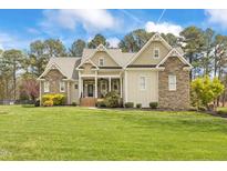 Stunning stone and siding home featuring a large manicured lawn and classic architectural details at 2000 Silverleaf Dr, Youngsville, NC 27596