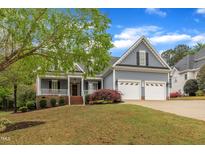 Charming home with a welcoming front porch, attached two-car garage, and well-manicured lawn at 212 Hein Dr, Clayton, NC 27527