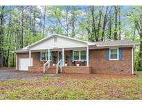 Charming brick ranch featuring a covered front porch and attached garage at 2314 Clements Dr, Durham, NC 27704
