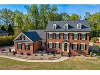 Traditional two-story brick home with a manicured lawn and mature trees at 3001 Greystone Dr, Rocky Mount, NC 27804