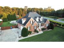 Charming brick home featuring manicured lawn, driveway, attached garage, and attractive landscaping at 3098 Creek Point Rd, Graham, NC 27253
