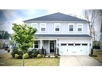Charming two-story home featuring a well-manicured lawn and an attached two-car garage at 408 Torwood Cir, Apex, NC 27523