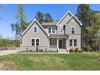 Charming two-story home boasts a welcoming front porch and well-manicured lawn at 50 Gadwall Ct, Zebulon, NC 27597