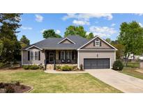 Charming single-story home with a stone-accented front porch, well-manicured lawn, and attached two-car garage at 503 Fish Pond Ct, Rolesville, NC 27571