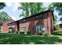 Brick apartment building with green shutters, well-kept landscaping, and mature trees at 5804 Falls Of Neuse Rd # E, Raleigh, NC 27609