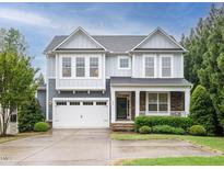 Charming two-story home with a two-car garage and a well-maintained front yard and stone accents at 65 N Wilders Ridge Way, Clayton, NC 27527