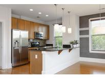 Modern kitchen features stainless steel appliances, granite countertops, and pendant lighting at 700 Finsbury St # 306, Durham, NC 27703