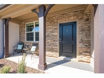 Inviting front door with a stone facade, covered entrance, and stylish welcome mat at 746 Wickham Ridge Rd, Apex, NC 27539