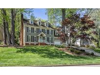 Traditional two-story home featuring gray siding, black shutters, and a well-manicured front lawn at 7705 Glenharden Dr, Raleigh, NC 27613