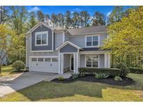 Charming two-story home with a manicured lawn, attached garage, and welcoming entrance at 858 Lake Artesia Ln, Fuquay Varina, NC 27526