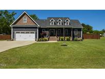 Charming two-story home with well-maintained lawn, attached garage, and inviting front porch at 90 Pump Station Rd, Erwin, NC 28339