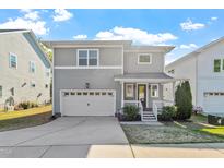 Charming two-story home with a well-manicured front yard, attached garage, and inviting front porch at 905 Moye Dr, Raleigh, NC 27606