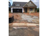 Exterior view of a charming single-story home with a two-car garage and unfinished front yard at 100 Slippery Elm Rd, Youngsville, NC 27596