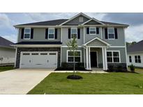 Two-story home with an attached two-car garage, a covered front porch, mature grass, and landscaped yard at 107 Southern Estates Dr, Sanford, NC 27330