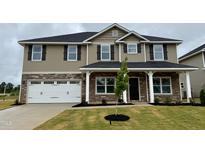 Charming two-story home with a stone facade and a two-car garage, complemented by a freshly landscaped yard at 107 Southern Estates Dr, Sanford, NC 27330