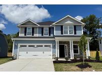 Charming two-story home featuring a two-car garage and stone-accented entryway at 119 Southern Estates Dr, Sanford, NC 27330