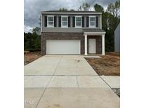 Two-story home with a brick and gray siding facade, attached two-car garage, and concrete driveway at 132 N Keatts Winner Ct, Wilson's Mills, NC 27520