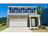 Charming two-story home with brick and siding, featuring a two-car garage and inviting front entrance at 132 N Keatts Winner Ct, Wilson's Mills, NC 27520