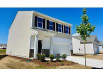 New construction home featuring a two-car garage, black shutters, manicured yard, and neutral color palette at 133 N Keatts Winner Ct, Wilson's Mills, NC 27520