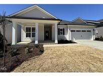 Charming single-story home boasts a welcoming front porch and a convenient two-car garage at 1636 Raven Falls Dr, Wendell, NC 27591