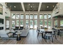 Bright resident lounge featuring modern furniture, fireplace, high ceilings, and view of pool at 1636 Raven Falls Dr, Wendell, NC 27591