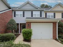 Charming two-story townhome featuring an attached one-car garage and well-manicured landscaping at 2067 White Pond Ct, Apex, NC 27523