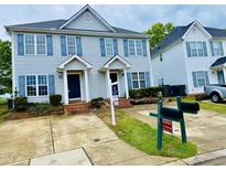 Charming townhome featuring a well-maintained lawn and a symmetrical facade with blue shutters at 2125 Ventana Ln, Raleigh, NC 27604