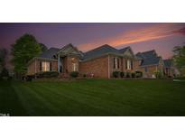 Charming brick home featuring a manicured lawn and lovely landscaping with a beautiful sunset backdrop at 2326 Marlow Dr, Burlington, NC 27215