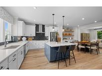 Bright, open kitchen with white cabinets, stainless steel appliances, and a large island with bar seating at 4504 Mint Leaf Ln, Raleigh, NC 27612