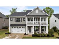 Charming two-story home with a welcoming front porch and a two-car garage, showcasing classic architectural details at 4803 Stony Falls Way, Knightdale, NC 27545