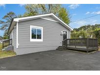 Charming single-story home featuring gray siding, a dark porch, and a well-maintained front yard at 500 John St St, Clayton, NC 27520