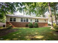 Ranch style home with brick and vinyl siding, manicured lawn and mature trees offering curb appeal at 505 E Graham St, Mebane, NC 27302