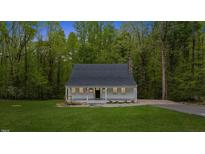 Charming home featuring a covered front porch, manicured lawn, and mature trees at 5541 Old Still Rd, Wake Forest, NC 27587