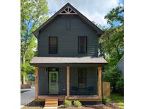 Charming two-story home featuring a quaint front porch, dark gray siding and wood post supports at 612 E Ellerbee St, Durham, NC 27704