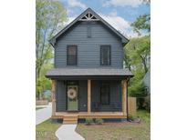 Charming two-story home with a welcoming front porch, natural wood columns, and tasteful landscaping at 612 E Ellerbee St, Durham, NC 27704