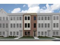 Modern townhouse exterior features a brick facade, symmetrically placed windows, and a well-manicured lawn at 668 Bandon Aly, Cary, NC 27513