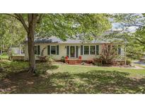 Charming single-story home featuring a manicured lawn, mature trees, and a welcoming front entrance at 700 Sawmill Rd, Raleigh, NC 27615