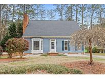 Charming single-story home featuring a bay window, brick chimney, and a well-manicured front yard at 7112 Benhart Dr, Raleigh, NC 27613