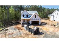 New two-story home under construction featuring a covered entry, garage, and durable weather-resistant wrap at 85 Purslane Dr, Franklinton, NC 27525