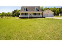 Charming Cape Cod-style home with a covered front porch and large lawn at 850 Cheatham Mabry Rd, Henderson, NC 27537