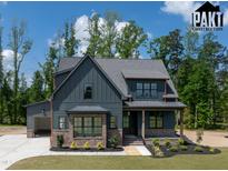 Two-story home showcases a mixed material facade, complemented by a lush lawn and professional landscaping at 8620 Dukes Lake Rd, Zebulon, NC 27597