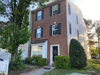 Two-story townhome boasting a brick facade, complemented by a well-maintained, manicured lawn and garden area at 8650 Neuse Landing Ln # 101, Raleigh, NC 27616