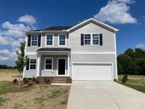 Charming two-story home with gray siding, black shutters, and a spacious two car garage at 89 Grove Township Way, Angier, NC 27501