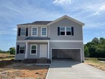 New two-story home with gray siding, black shutters, an attached two-car garage, and unfinished landscaping at 89 Grove Township Way, Angier, NC 27501