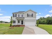 Charming two-story home with gray siding, an attached garage, and a well-manicured lawn at 89 Grove Township Way, Angier, NC 27501
