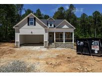 Charming home featuring stone accents, a covered front porch, and attached garage at 90 Purslane Dr, Franklinton, NC 27525