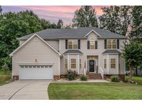 Charming two-story home with neutral siding, a well-manicured lawn and an attached two-car garage at 106 Teak Cir, Garner, NC 27529