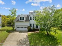 Charming two-story home featuring a two-car garage and a beautifully landscaped front yard with mature trees at 113 Laurel Branch Dr, Cary, NC 27513