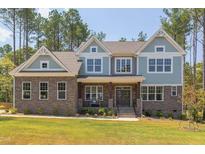 Charming two-story home showcasing a stone facade and varied siding for enhanced curb appeal at 205 Riverine Dr, Pittsboro, NC 27312