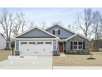 Charming home with stone accents, red front door, and a two-car garage at 21 Artesa Ct, Fuquay Varina, NC 27526